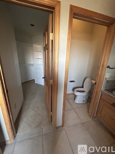 A bathroom with a toilet and sink is shown through a doorway.