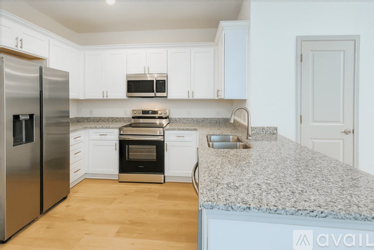 A kitchen with white cabinets and a granite countertop.