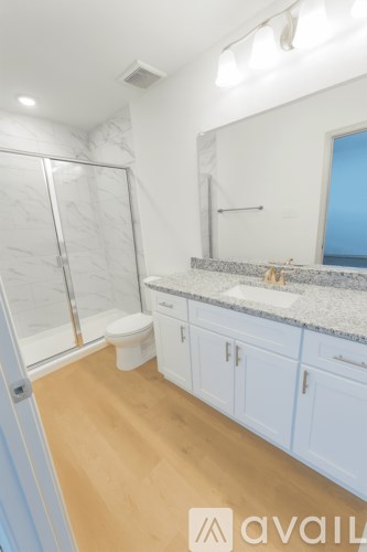 A bathroom with a walk-in shower, toilet, and sink.