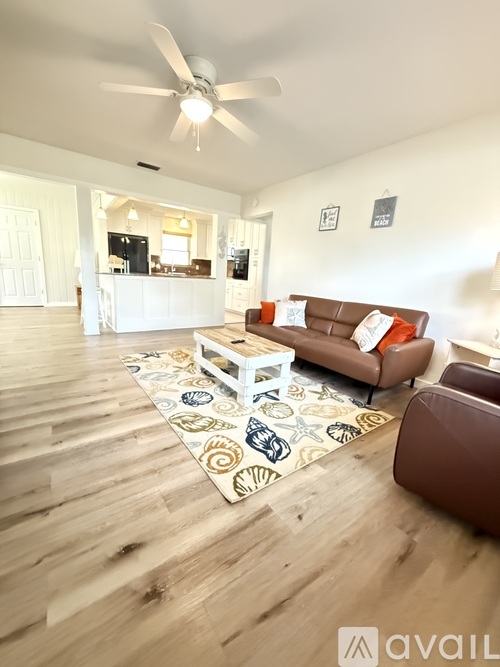 A living room with a brown couch and a white coffee table.