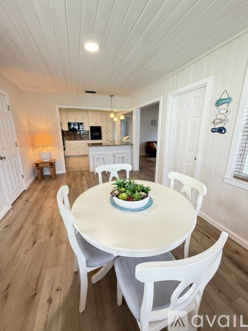 A dining room with a table and chairs.