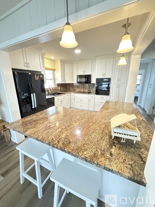 A kitchen with granite countertops and white cabinets.