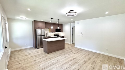 A kitchen with a refrigerator, microwave, and oven is available for rent.