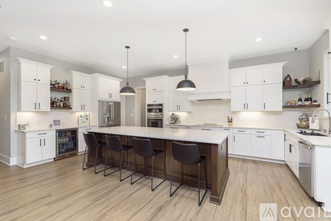 A kitchen with white cabinets and a wooden island.