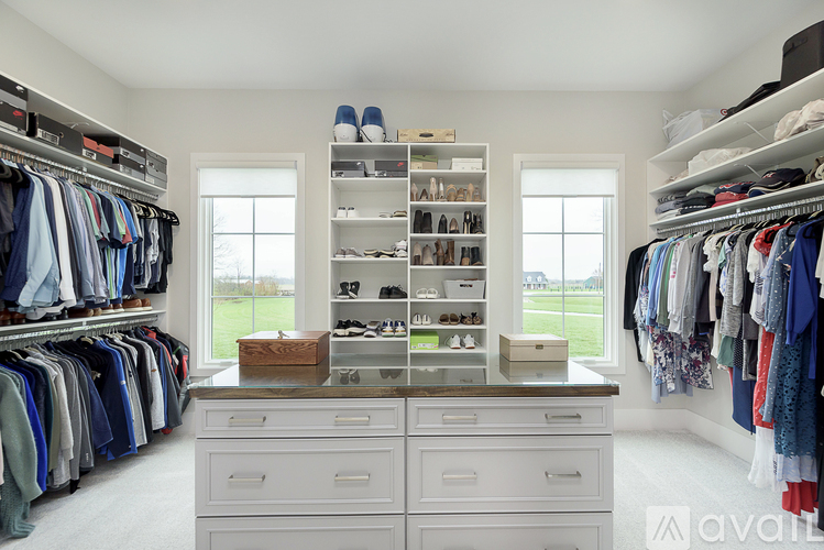 A spacious walk-in closet with white shelves and drawers.