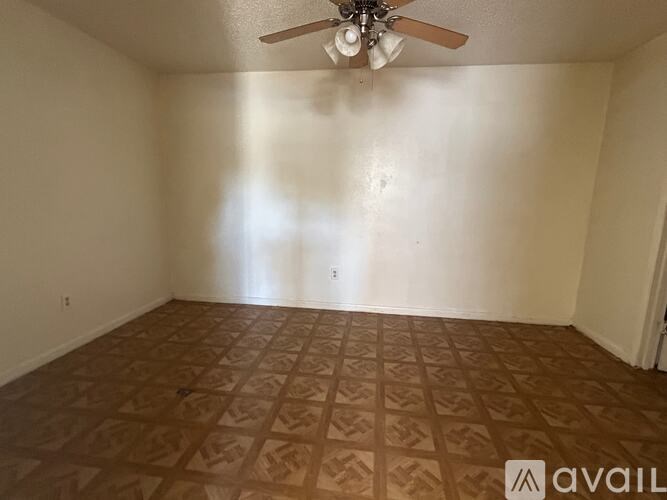 A room with a ceiling fan and patterned flooring.