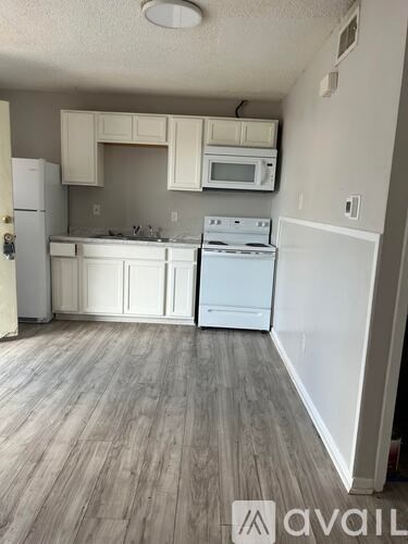 A kitchen with white appliances and cabinets.