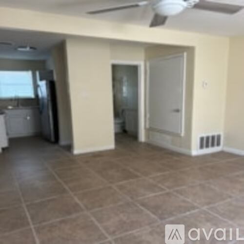 A room with a fan and tile flooring.