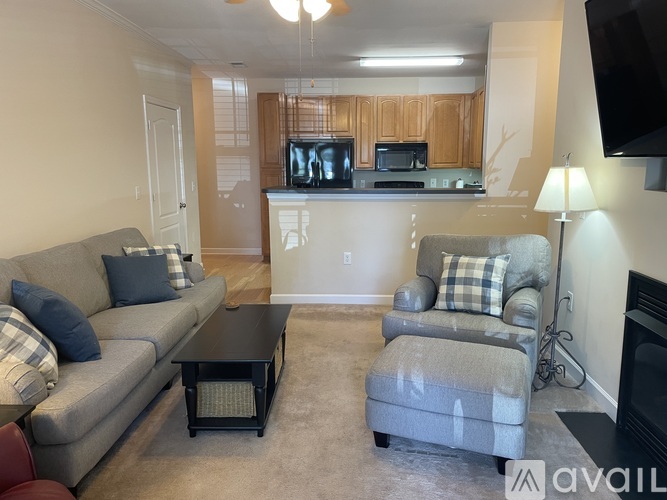A living room with a grey couch, a black coffee table, and a fireplace.