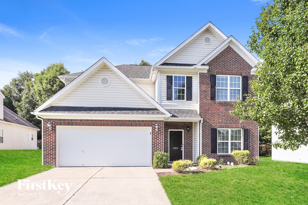 A two-story house with a garage is for sale.