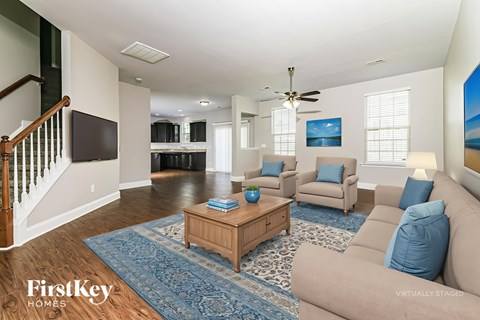 A living room with a blue rug and a wooden coffee table.