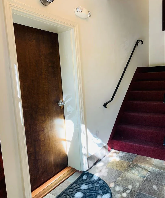 A wooden door is open to a staircase.