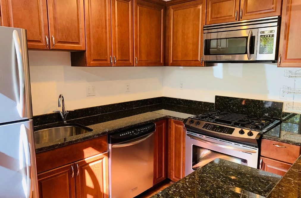 A kitchen with a stove, oven, refrigerator, and microwave.