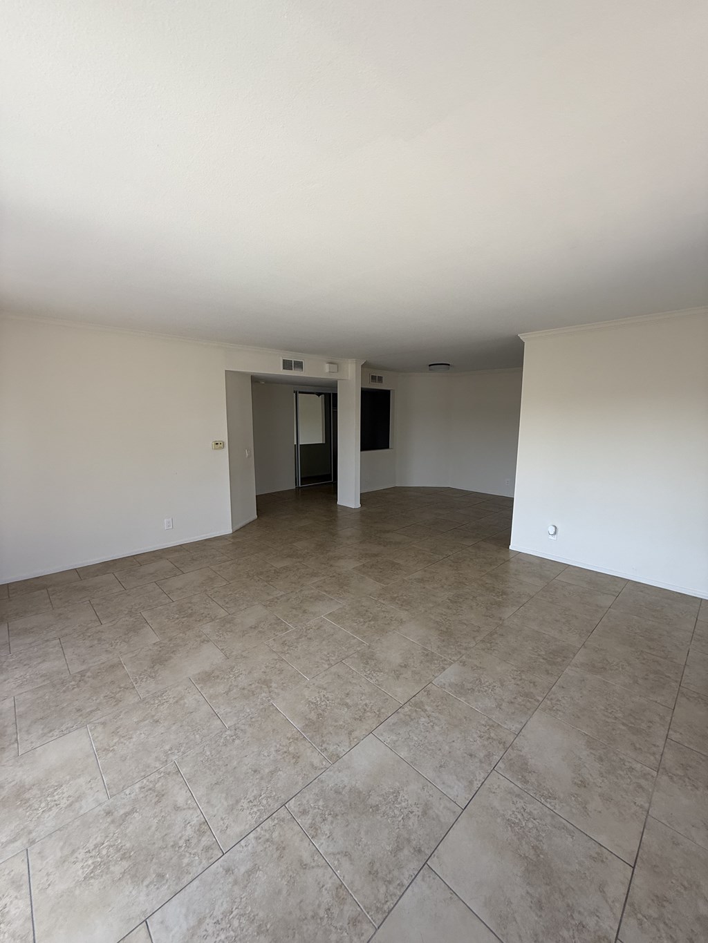 A room with a tiled floor and a doorway leading to another room.