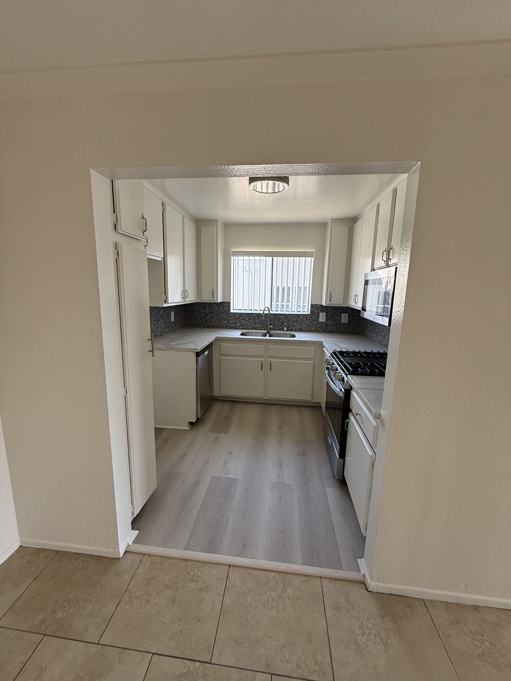 A kitchen with white cabinets and a black countertop.