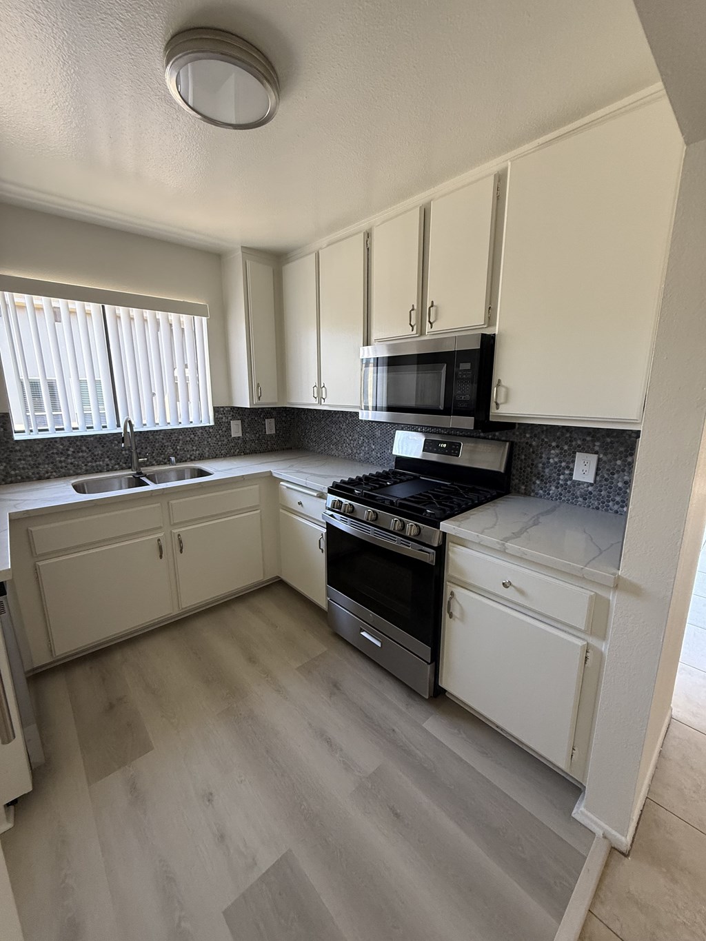 A kitchen with white cabinets and a black stove top oven.