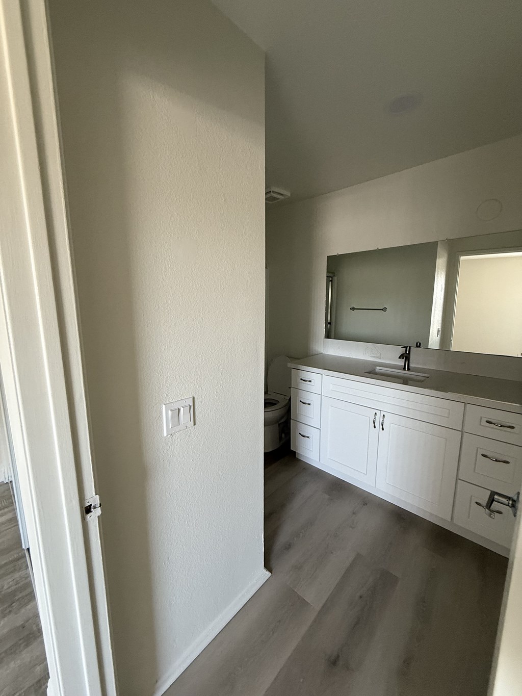 A bathroom with a sink, mirror, and cabinets.