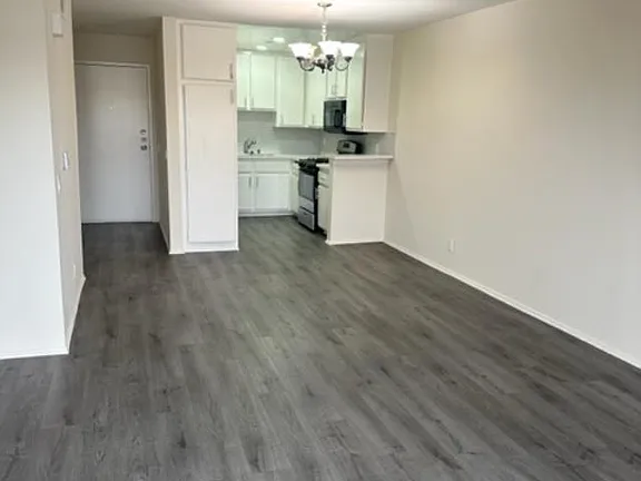 A kitchen with a white counter and a white fridge.