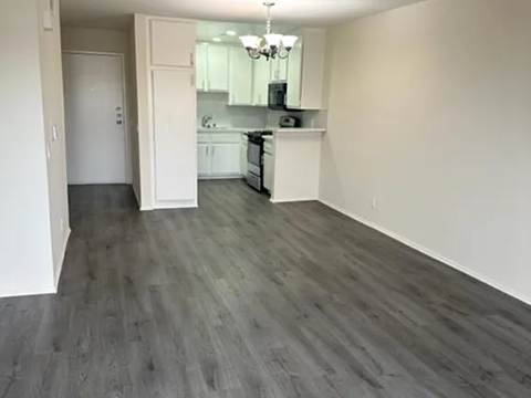A kitchen with a white counter and a white fridge.