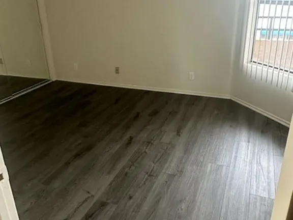 A room with a wooden floor and a window.