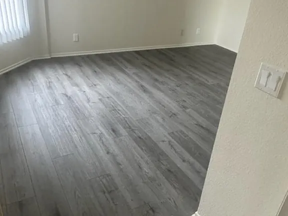 A room with a wooden floor and a window.