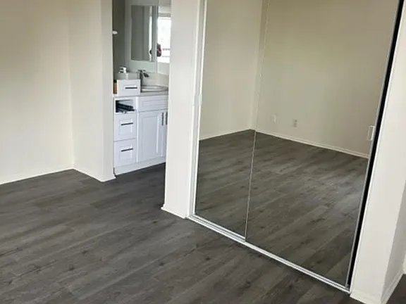 A bathroom with a white vanity and a mirror.