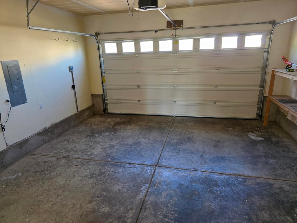A garage with a white door and a concrete floor.