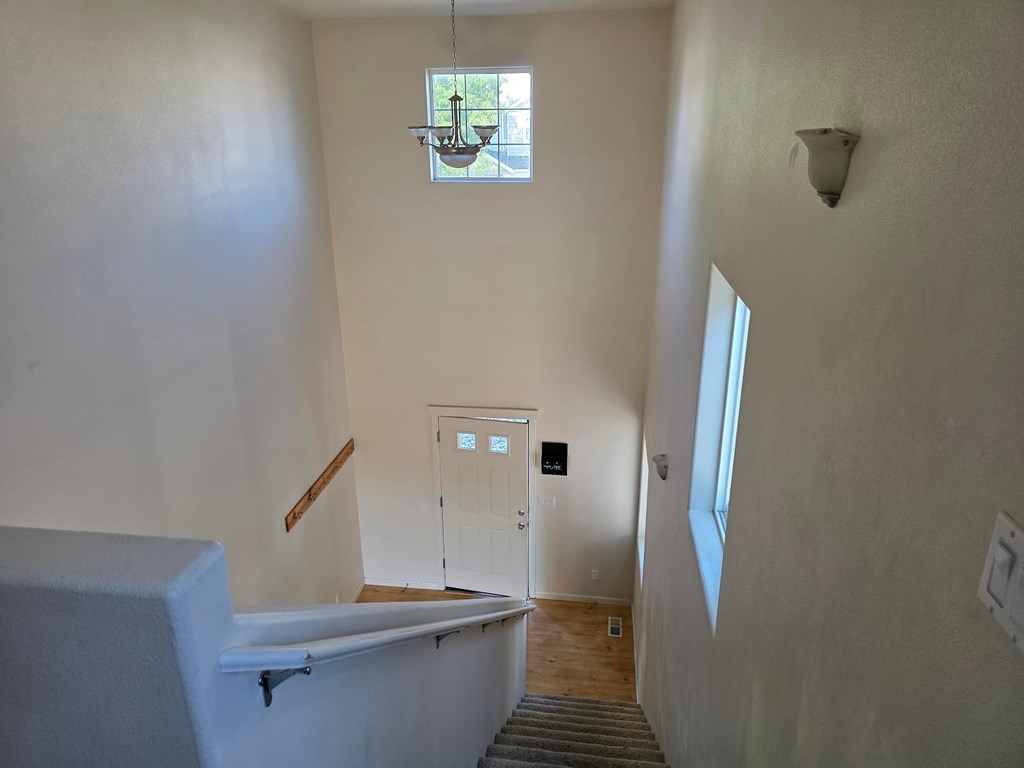 A white bathroom with a tub and stairs.