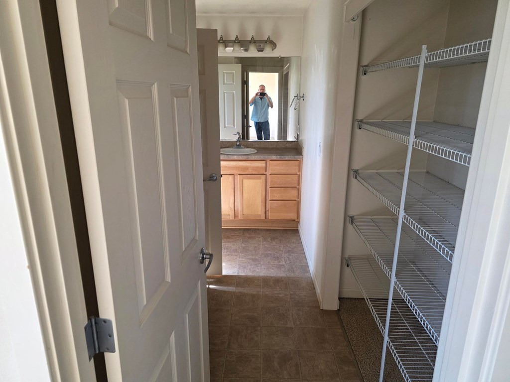 A man is standing in a hallway with a door open.