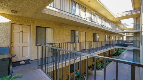 A balcony with a table and chairs is seen in the image.