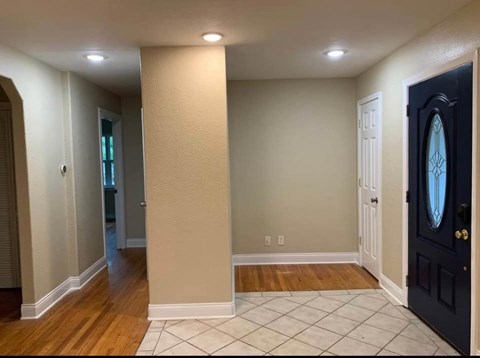 A hallway with a black door and a white door on the other side.