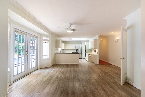 A spacious room with a kitchen area in the background.