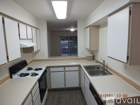 A kitchen with white cabinets and a black stove top oven.
