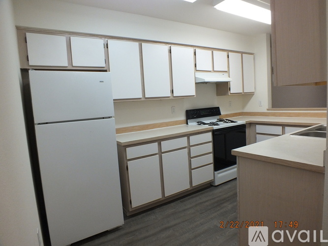 A kitchen with white cabinets and a black stove top oven.