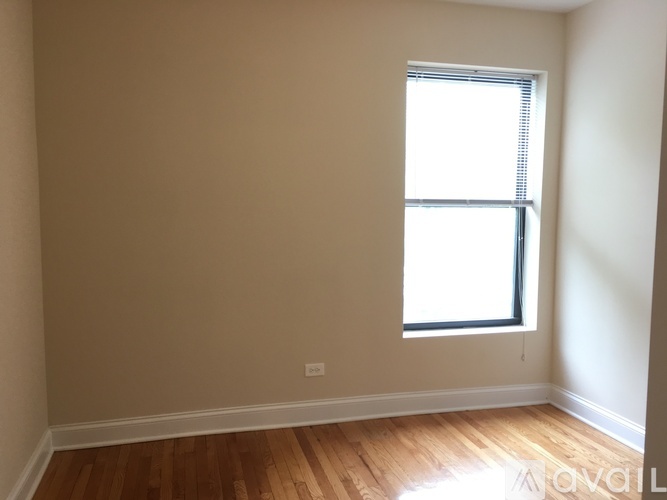 A room with a window and wooden flooring.