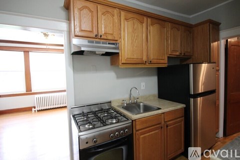 A kitchen with wooden cabinets and a stainless steel refrigerator.