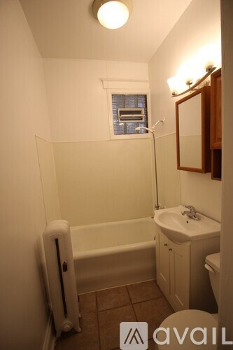 A small bathroom with a white tub and sink.