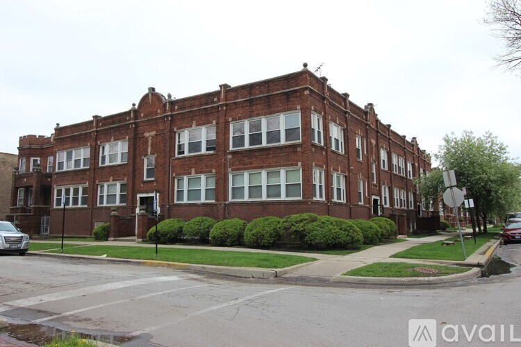A street view of a red brick building with a car parked in front.