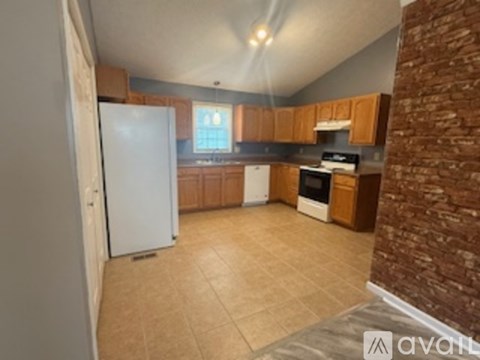 A kitchen with a white refrigerator and wooden cabinets.