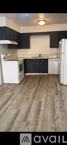A kitchen with dark cabinets and a white sink.