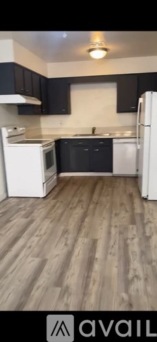 A kitchen with dark cabinets and a white sink.