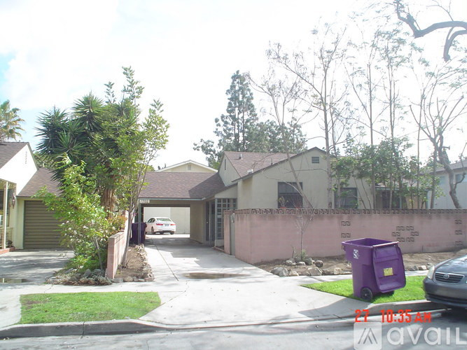 A residential street with houses and a parked car.