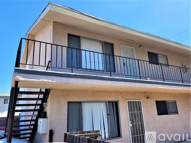 A two-story building with a balcony and a staircase.