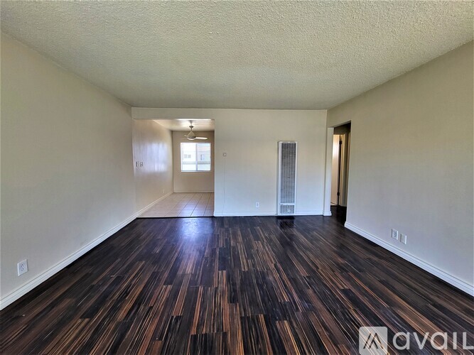 A room with wooden flooring and white walls.