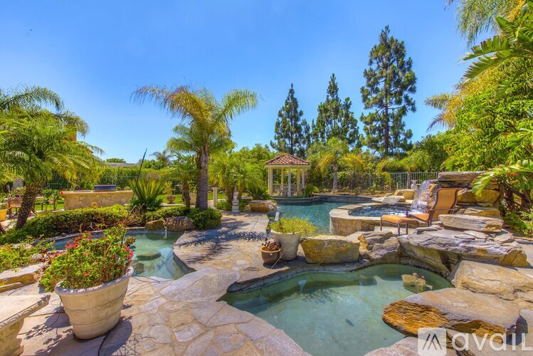 A beautiful outdoor swimming pool surrounded by rocks and plants.