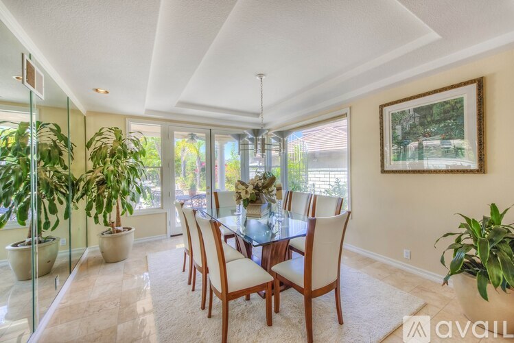 A dining room with a glass table and chairs.