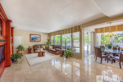 A living room with a television and a dining table.