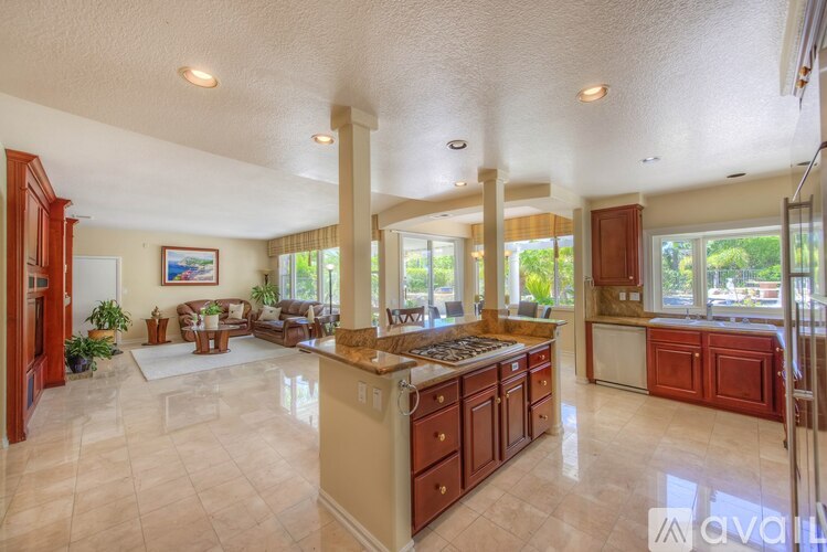 A spacious kitchen with a large island and a dining area with a table and chairs.
