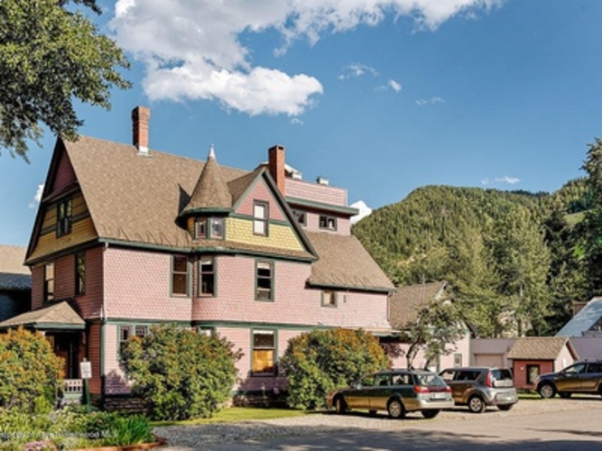 A large house with a green lawn in front.