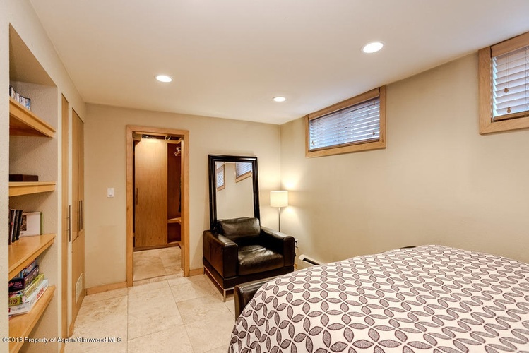 A bedroom with a bed, dresser, and mirror.